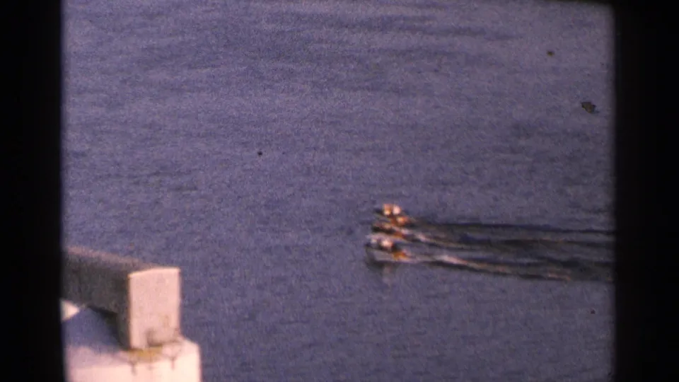 The motorboats reach the edge of the frame on the lake, while a concrete lakeside structure appears in the foreground.