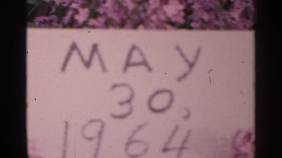 Final visible frame holds on the May 30, 1964 date card, bordered by flowers and dark scan edges from the 8mm film.