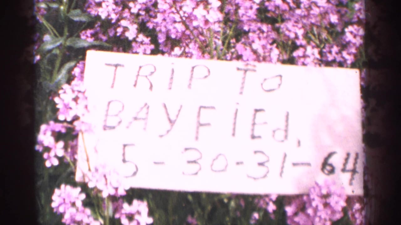 Handwritten trip title card placed among purple flowers.
