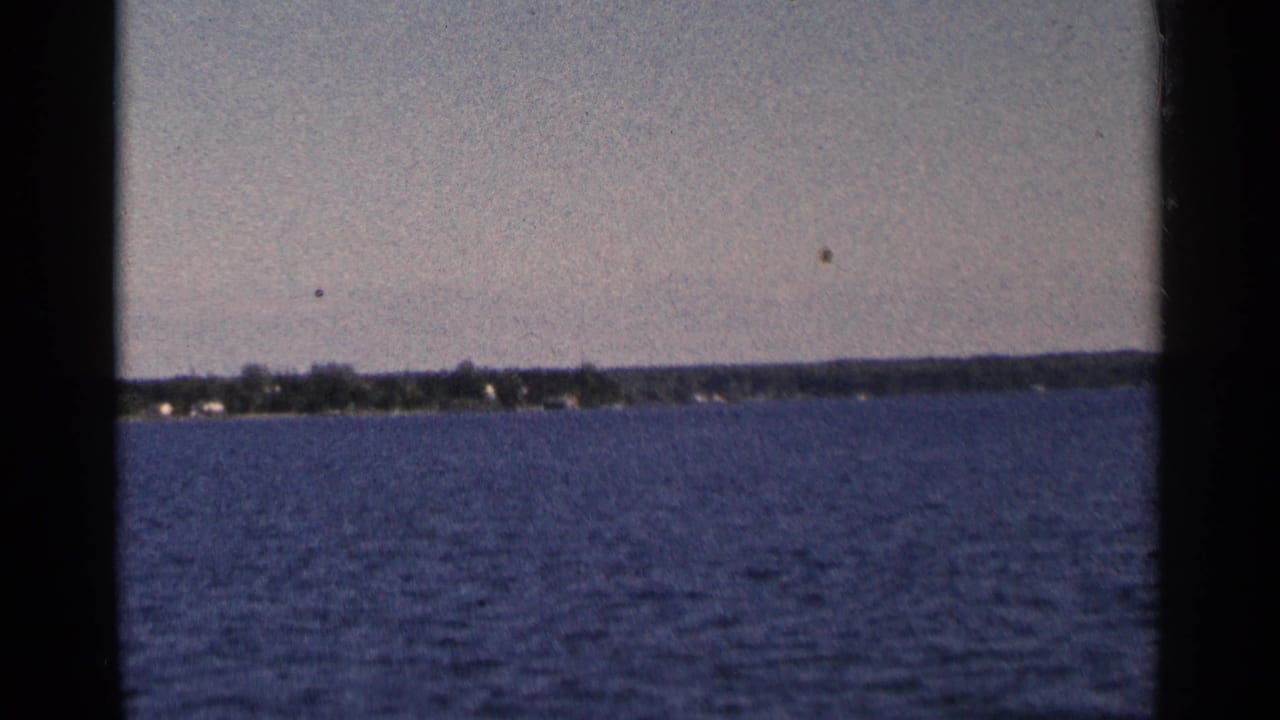 Wide waterway with a distant shoreline under a pale sky.