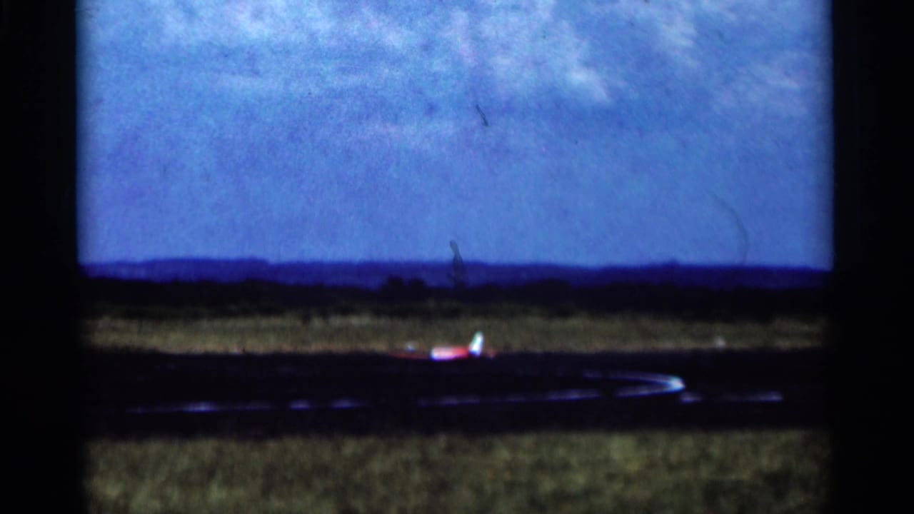 The small aircraft appears to accelerate along a Minnesota runway, seen through soft, blue-shifted 8mm footage.