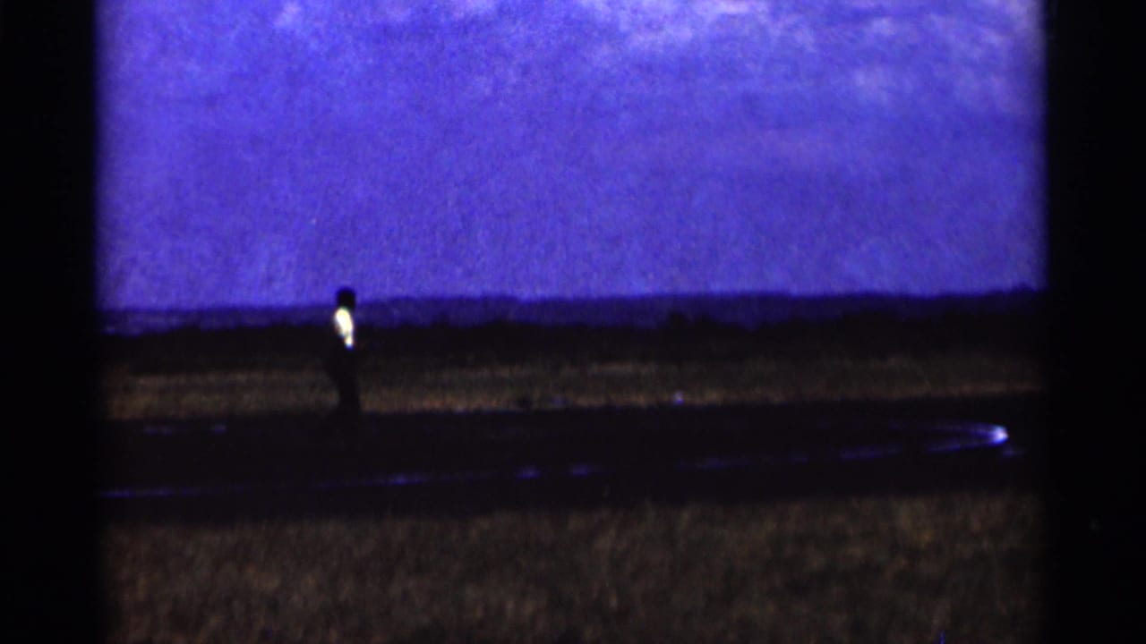 Small airplane on a dark airfield beneath a deep blue sky.