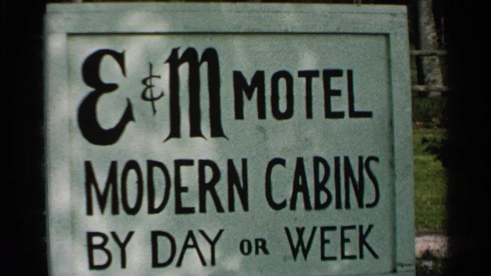 Close 1964 Washington Island view of the E&M Motel sign with large lettering for modern cabins by day or week.