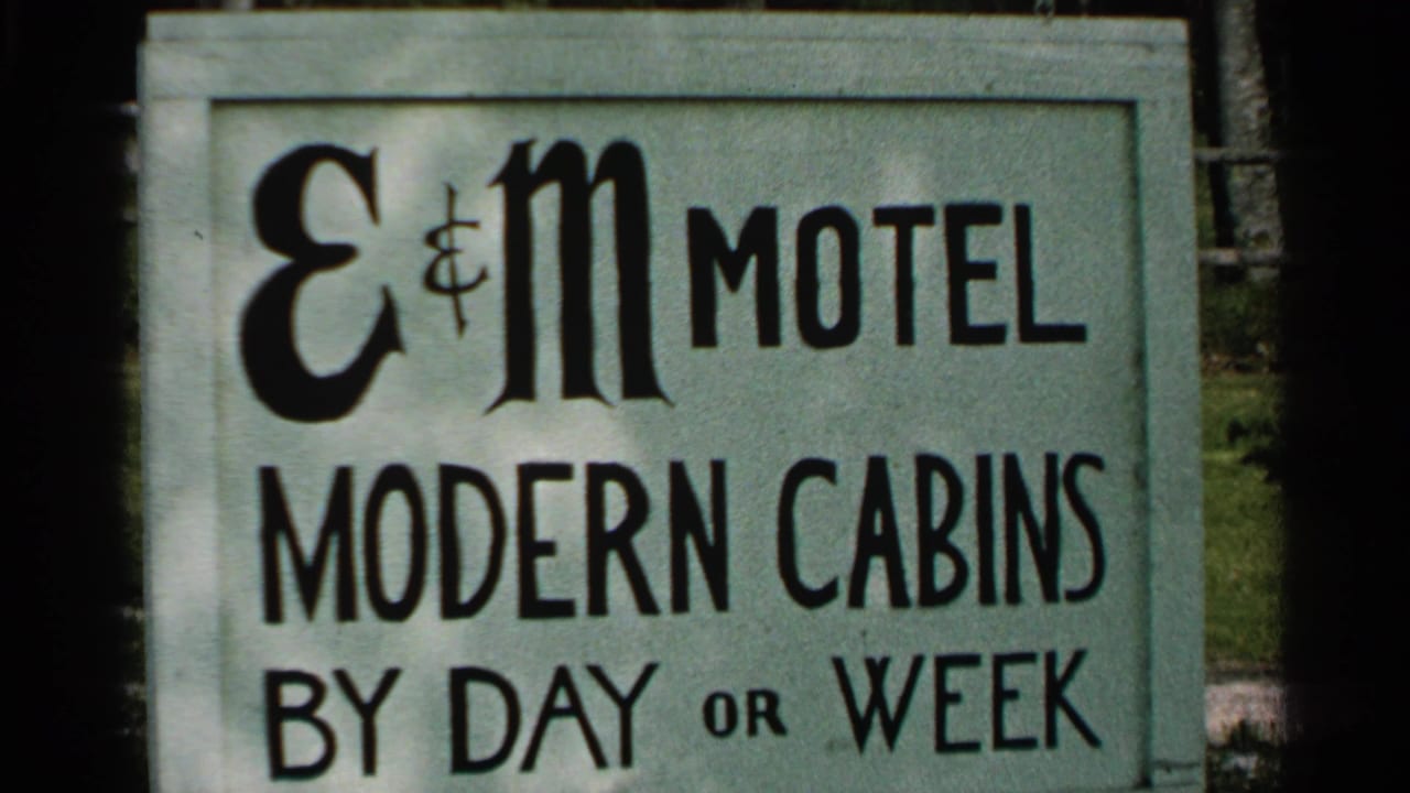 E&M Motel sign advertising modern cabins by day or week.