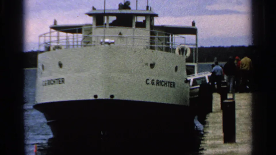 The ferry C.G. Richter is docked at Washington Island with passengers visible near the boarding area in 1964 home-movie footage.
