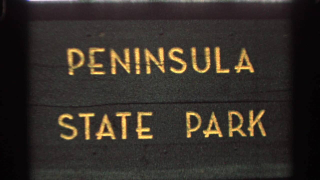 Dark Peninsula State Park sign with gold lettering filling the frame.