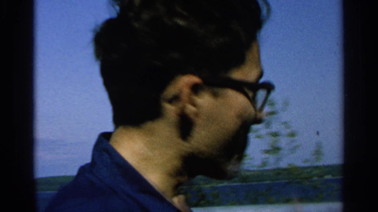 Young man in glasses and a dark collared shirt looks across the water on Washington Island, Wisconsin, in 1964 home-movie footage.