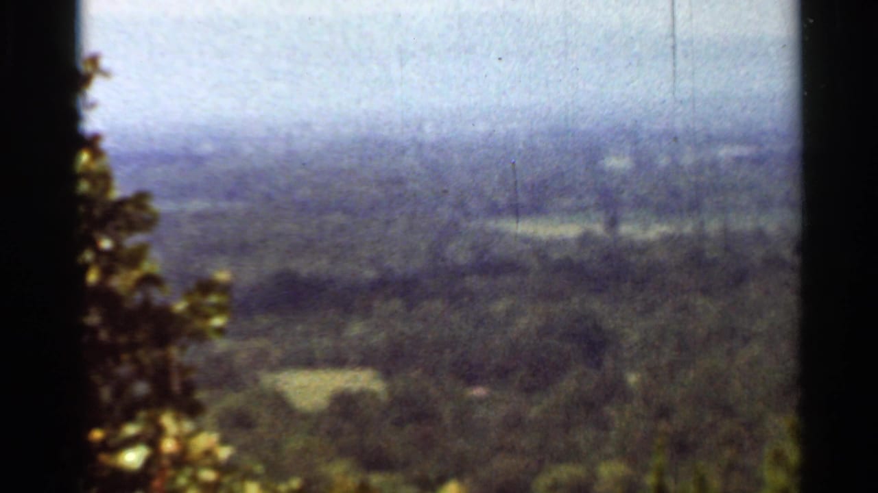 Hazy view over wooded hills and distant valley from a high overlook.