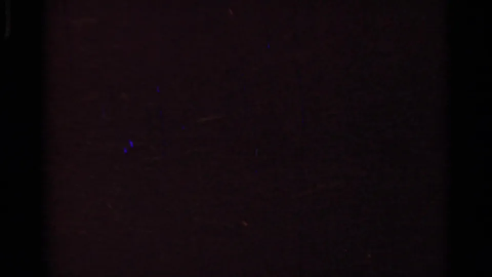 Dark Arkansas 1965 home-movie frame with little readable detail, showing reddish-brown tones and visible film texture.