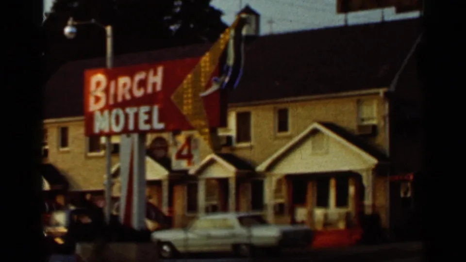 1965 Arkansas frame showing the red Birch Motel roadside sign, motel building, and light-colored parked car.