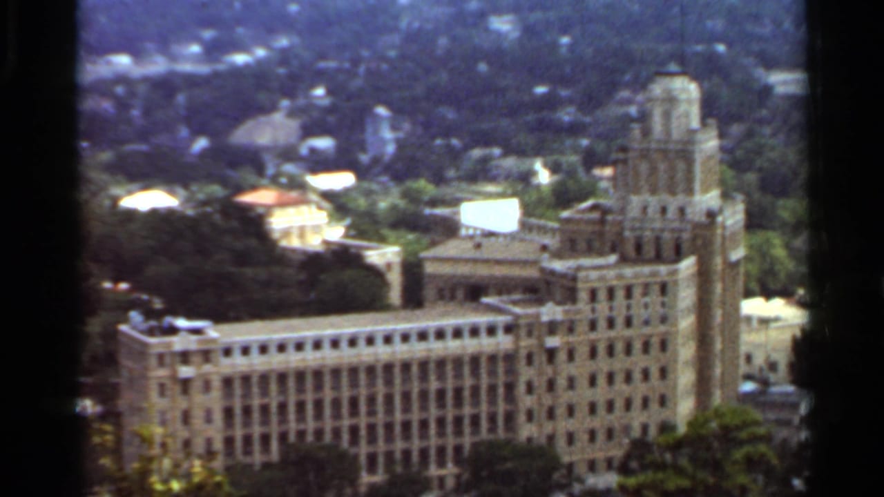 Large ornate building complex seen from above with trees around it.