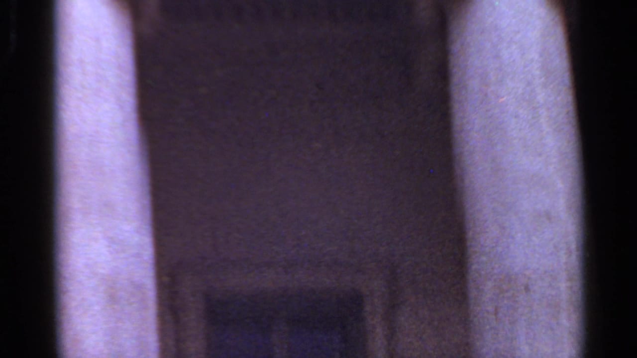 Soft close view of stone columns and a dark vertical architectural opening.