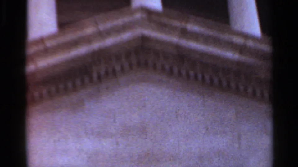 Angled home-movie view of steps, balustrade-like stonework, and masonry at an Arkansas civic building.