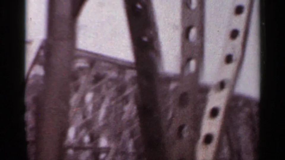 Soft 8mm frame showing close riveted bridge columns and angled steel members during the car's passage underneath.