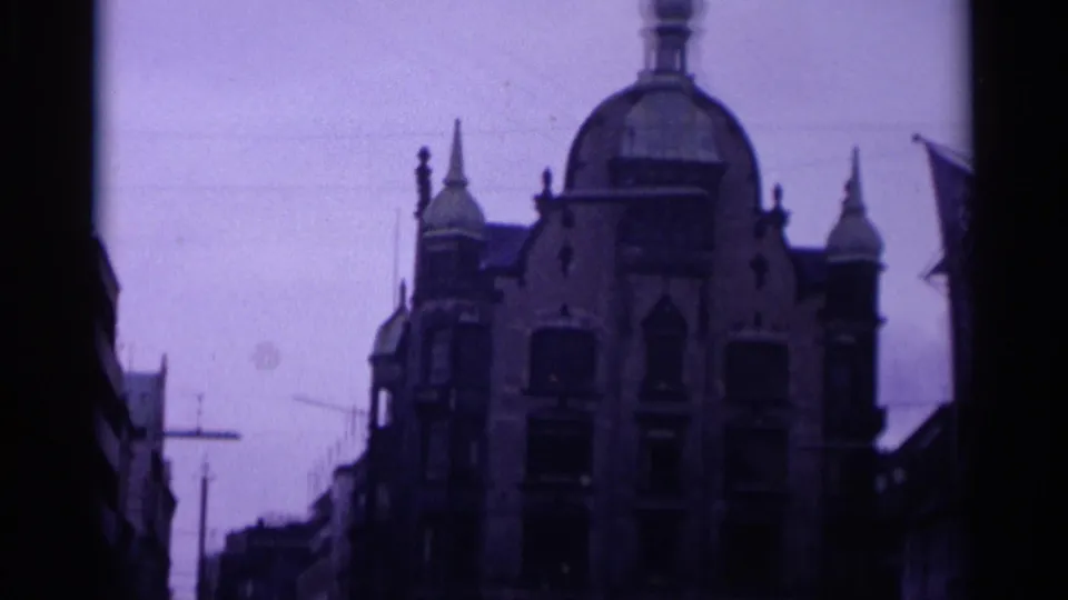 Copenhagen street view from 1965 showing an ornate domed building, narrow street framing, and strong purple color shift.