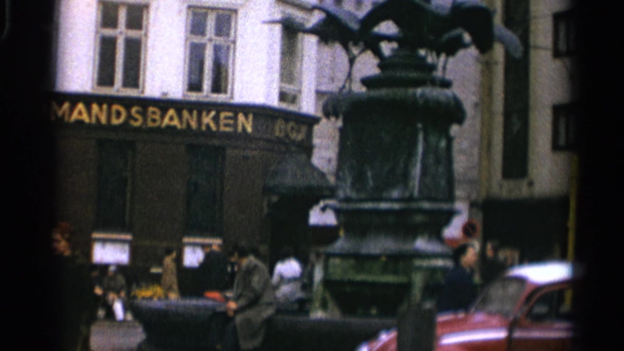 Ornate dark fountain in front of a bank building with pedestrians nearby.