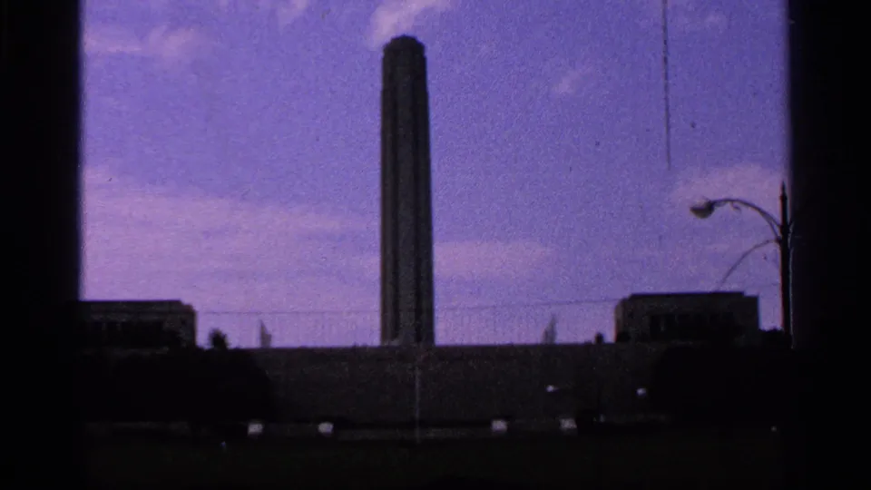 Kansas City Liberty Memorial tower appears from a ground-level 8mm view with sky, streetlamp, and low buildings.