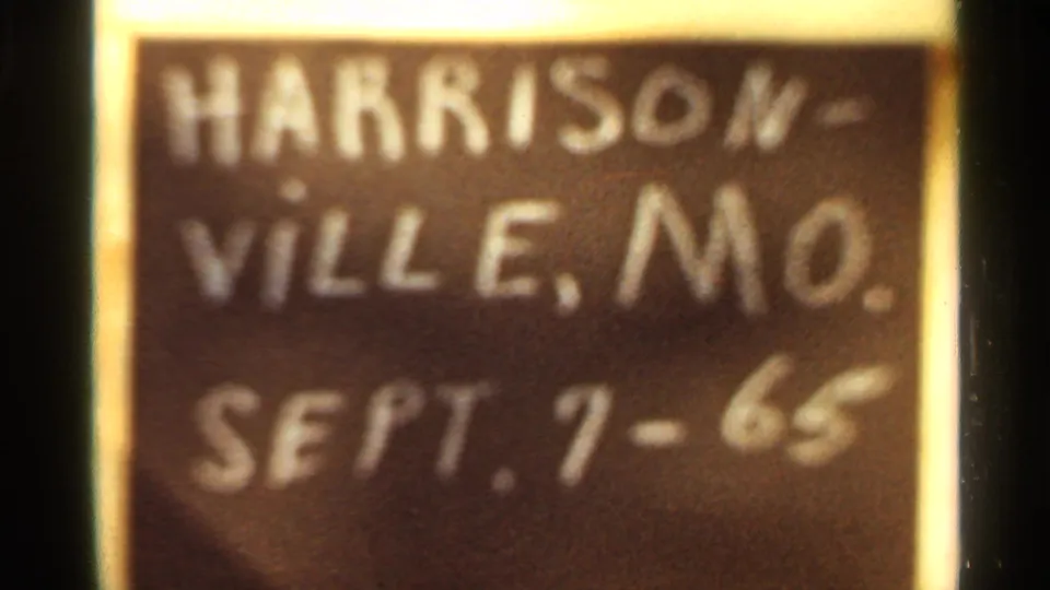 Soft-focus 8mm close-up of the Harrisonville, Mo. Sept. 7-65 chalkboard marker.