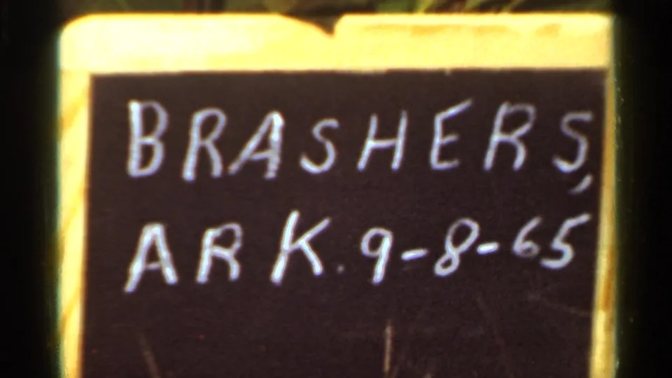 Tight home-movie frame of the handwritten Brashers, Arkansas date board, cropped near the right edge.