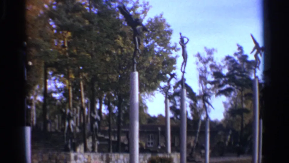1965 Leningrad park footage showing tall modernist figurative sculptures on columns above trees, landscaping, and a low building.
