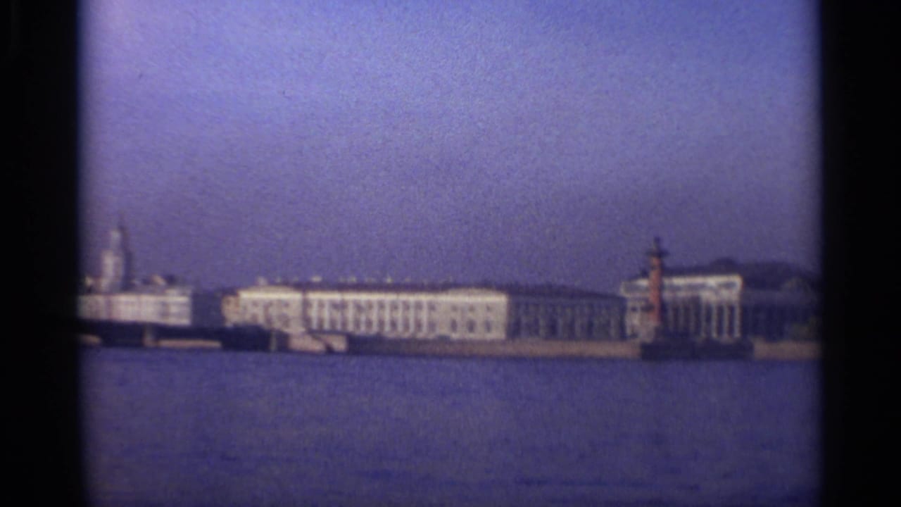 Waterfront buildings with a red marker tower near the shoreline.
