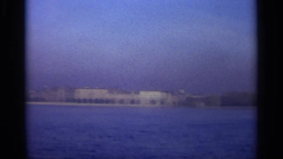 1965 8mm view of Leningrad waterfront buildings seen across blue water from offshore.
