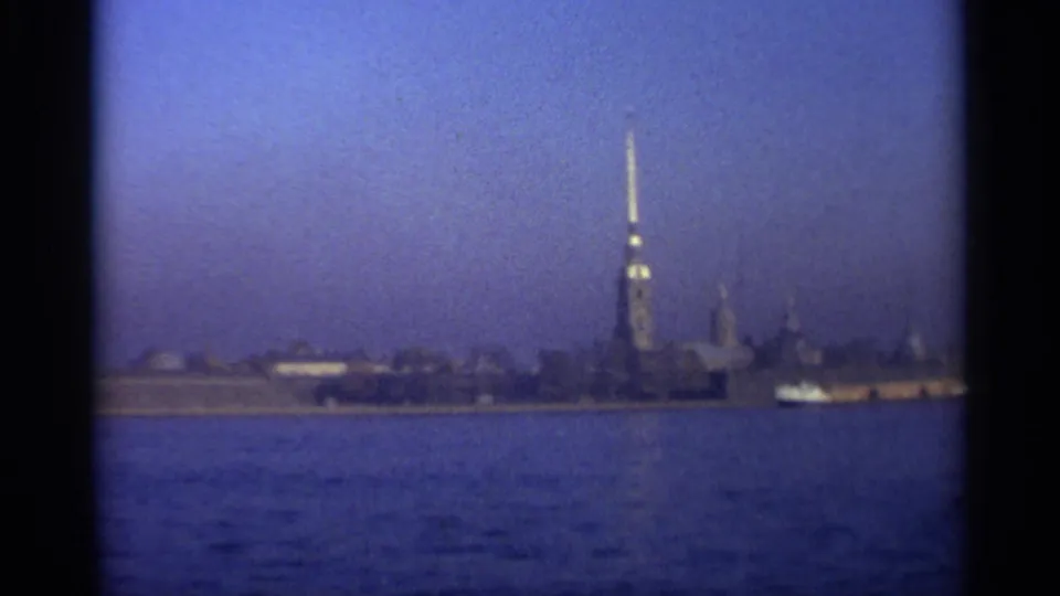 1965 Leningrad frame with the Peter and Paul Fortress spire in the distance and a small boat moving along the waterfront.