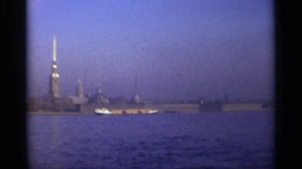 1965 Leningrad waterfront view with a small boat crossing beneath the distant Peter and Paul Fortress spire.