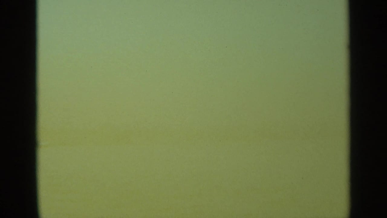 Mostly blank green-tinted film frame with dark vertical frame edges.