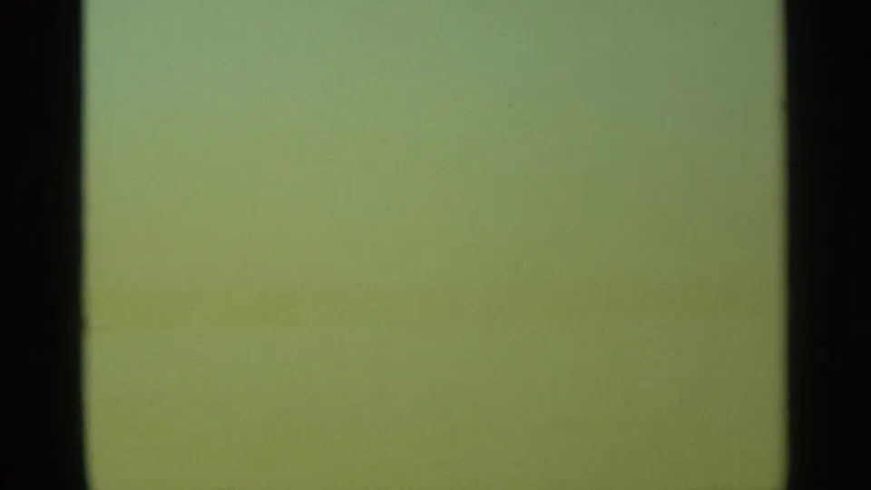 Green-tinted exposure or leader-like frame from the 8mm scan, bordered by dark vertical film edges.