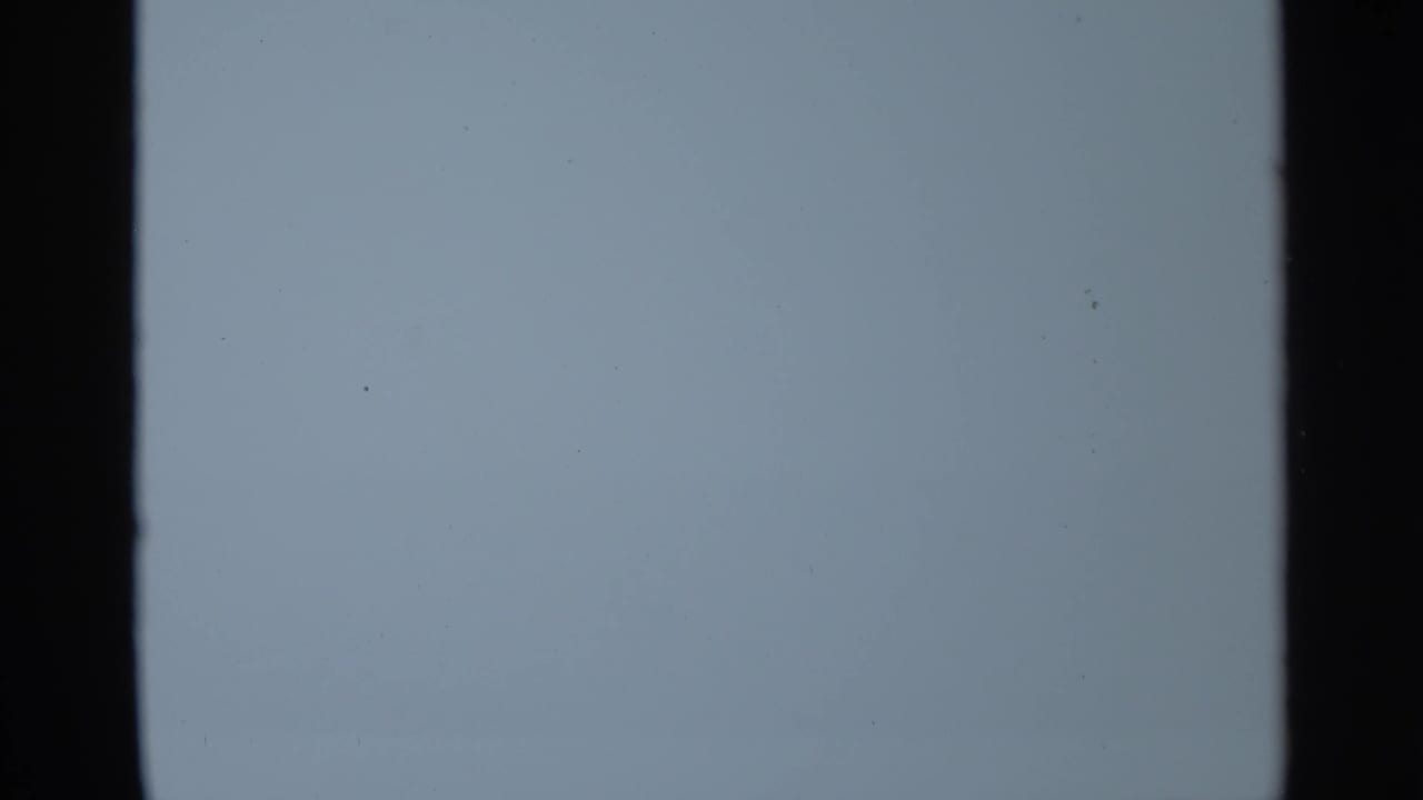 Blue-tinted blank 8mm frame from the 1965 Leningrad clip, showing grain and dark film-edge bands.