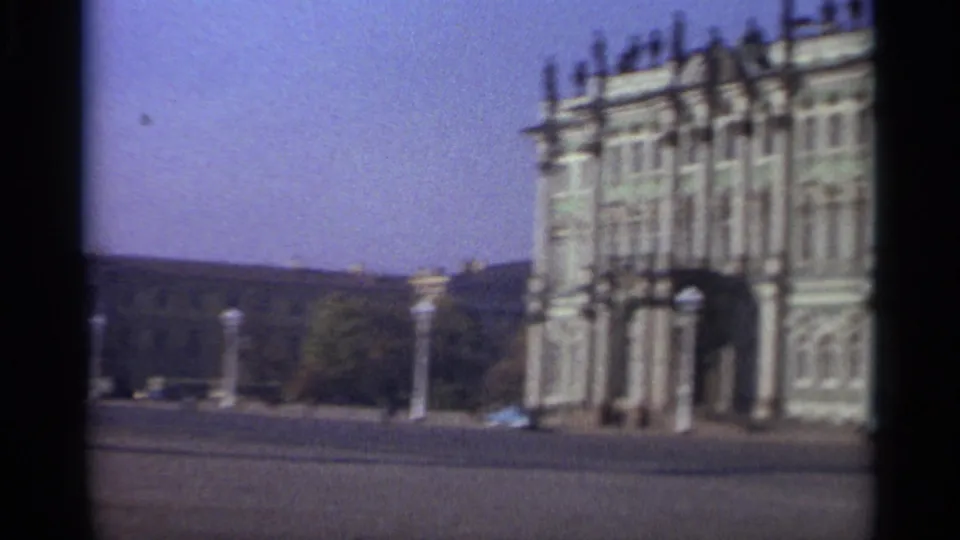 1965 Leningrad 8mm frame showing a grand green-and-white facade across a wide open square.