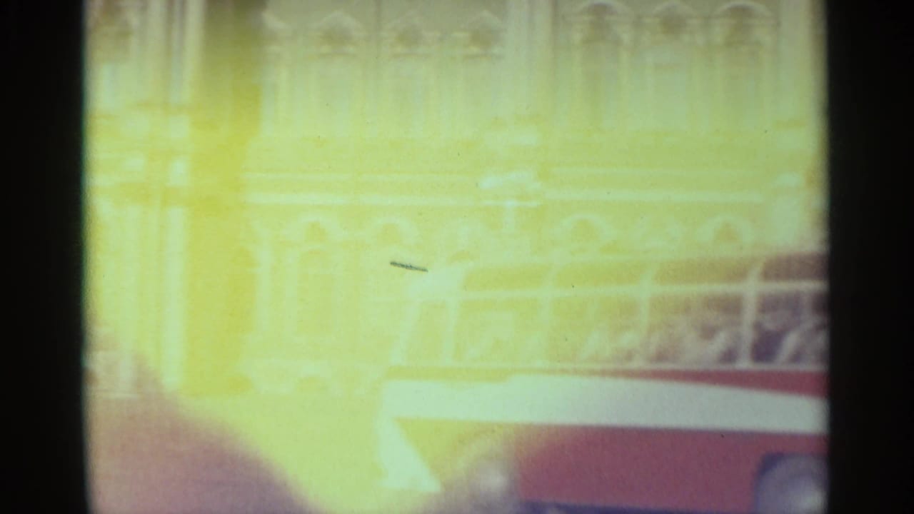 Overexposed 8mm frame from the Leningrad waterfront, with a vessel edge and faint architectural details visible.
