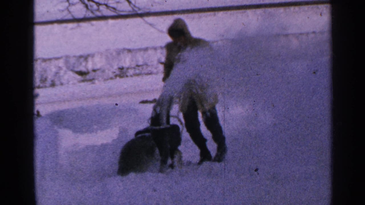 Man pushes a walk-behind snow blower through deep snow.