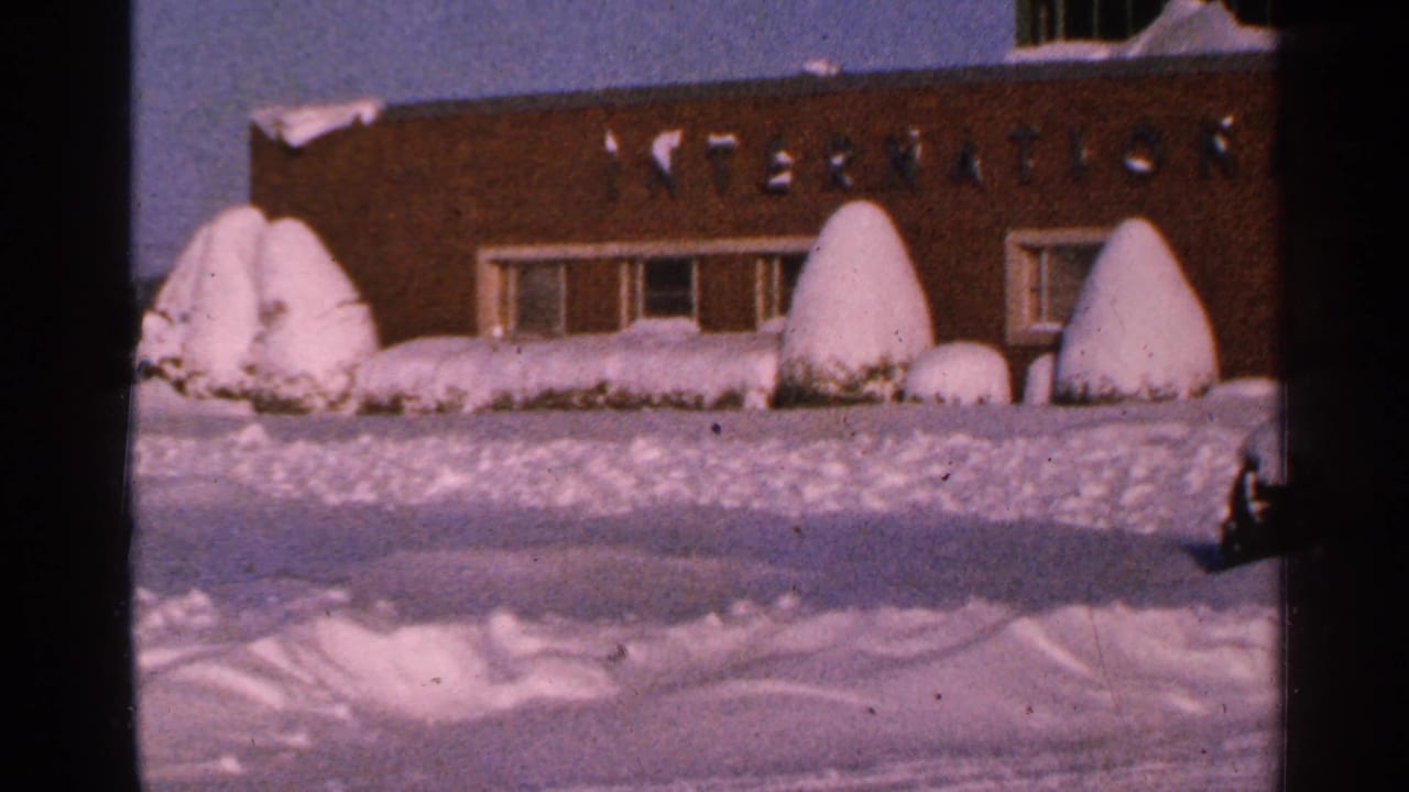 Brick building with partial INTERNATIONAL lettering behind a snowy foreground.