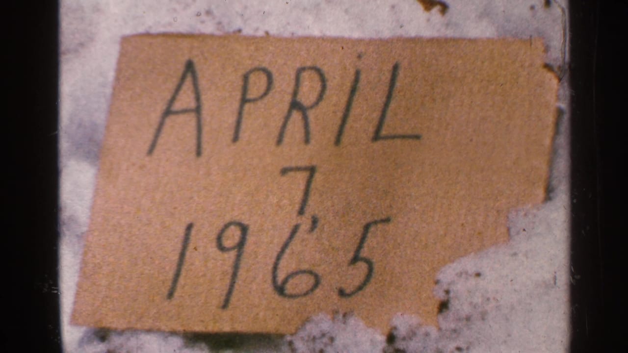 Cardboard date sign reading April 7 1965 beside snow.
