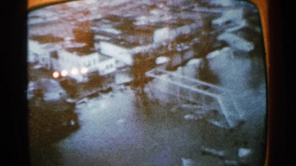 1965 Minnesota frame showing the DELAND marking in a snowy scene with bright lights and dark forms around the screen image.