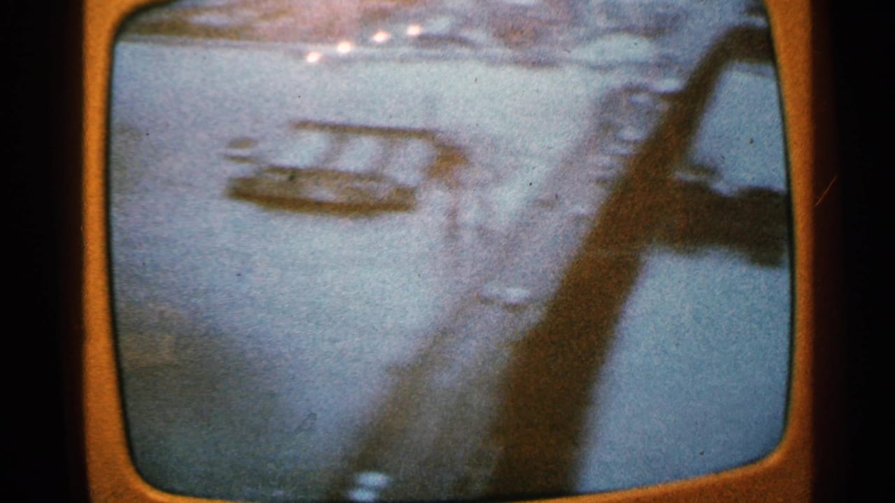 Minnesota 1965 frame appears to show a bridge over water, viewed in motion with blue-orange color shift and heavy grain.