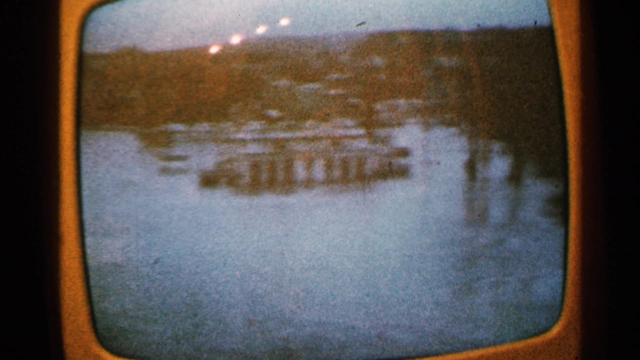 1965 Minnesota 8mm frame showing a hazy aerial view of river infrastructure, likely a bridge or dam, within a television screen image.