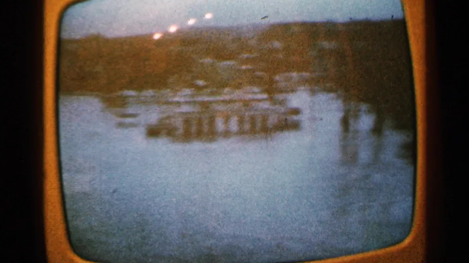 1965 Minnesota 8mm frame showing a hazy aerial view of river infrastructure, likely a bridge or dam, within a television screen image.