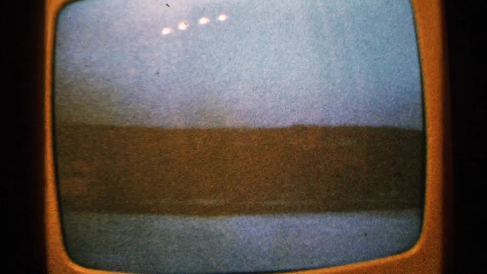 1965 Minnesota 8mm frame of a television screen with a low horizon and broad flooded area, heavily softened by glare and grain.