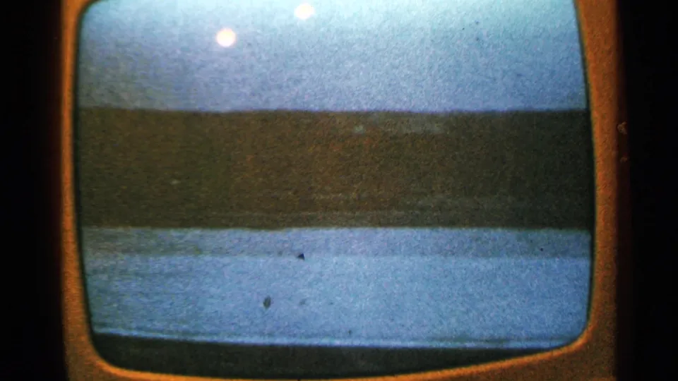 Filmed 8mm view of a television screen with a silhouetted skyline and pale water or ice foreground, Minnesota, 1965.