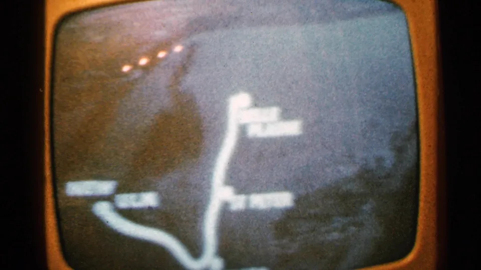 The travel map remains on screen, showing a bright route line and several soft labels that cannot be read with confidence.