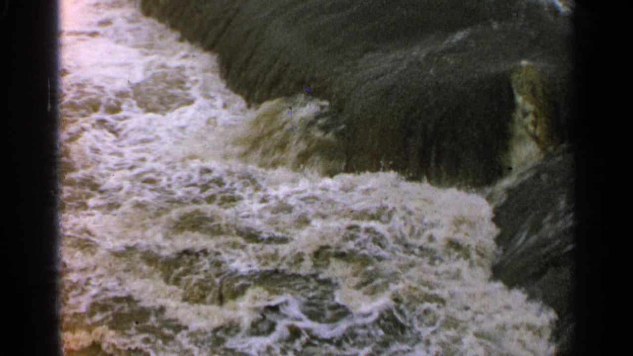 Close view of churning water or wet film texture beside the edge of another frame.
