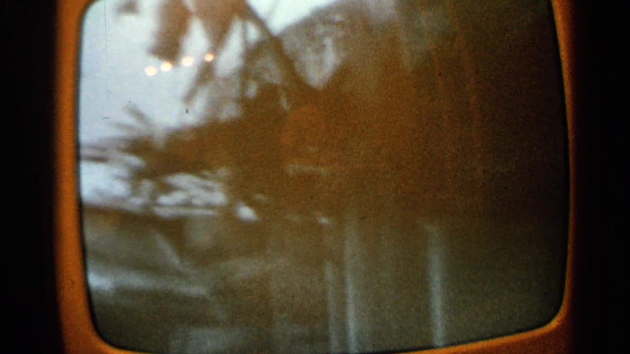 Old television screen with blurred roof debris and small lights near the top.