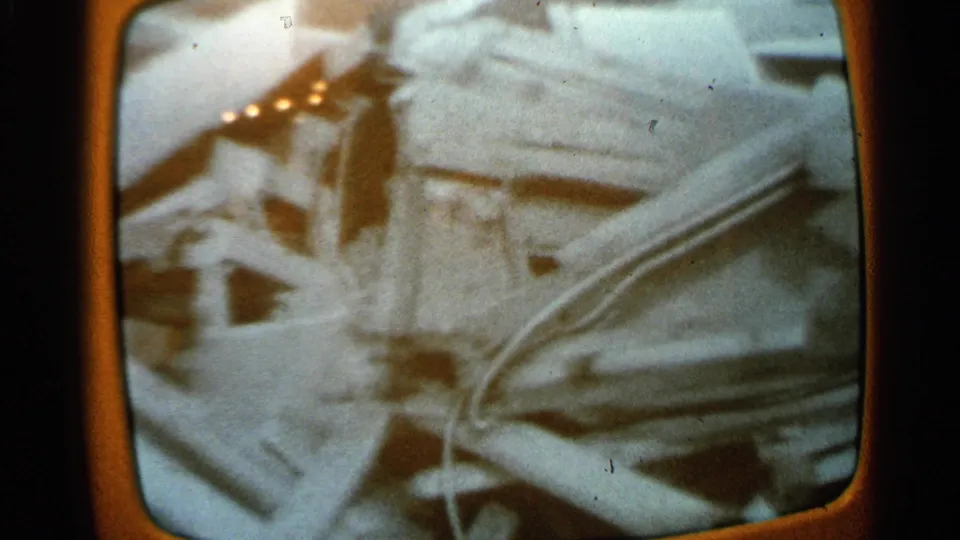Minnesota 1965 frame showing pale collapsed structural pieces, bent metal, and loose cables in a soft, grainy home-movie view.