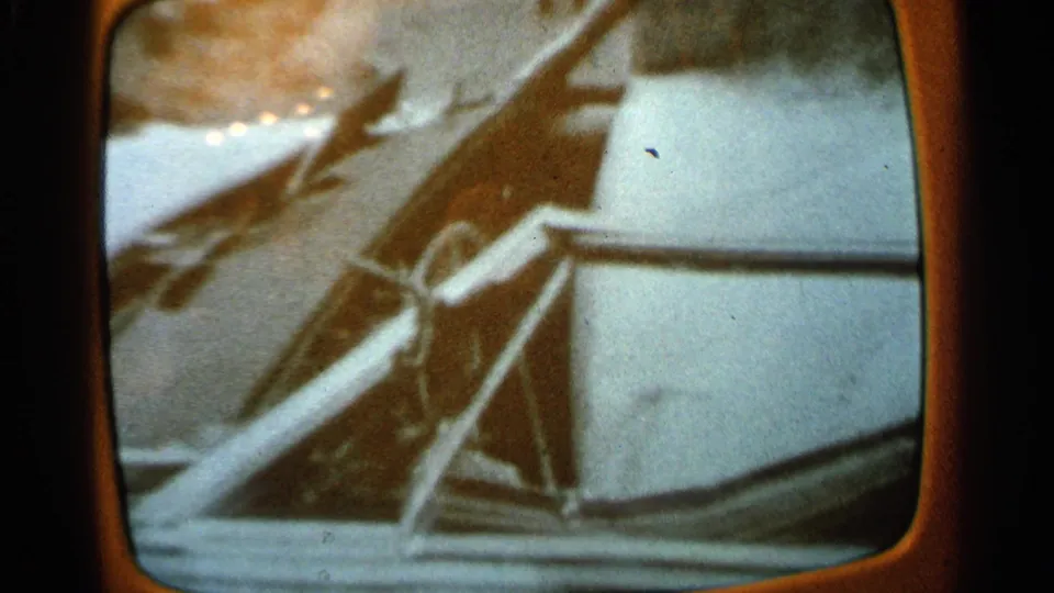 1965 Minnesota 8mm frame showing a wheel-like control and snowy exterior beyond the vehicle window.