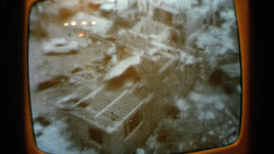 1965 Minnesota TV-screen footage shows floodwater, damaged structures, and debris within a dark rounded television frame.