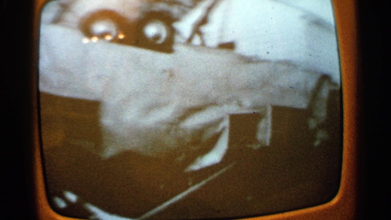Television screen with a pale damaged vehicle form and dark debris below.