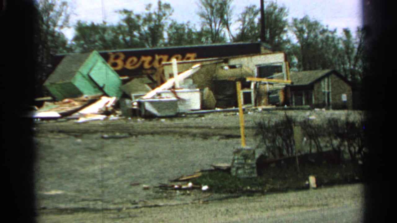 Damaged commercial building with debris and a partial Berger sign.